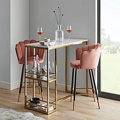 a dining table with two chairs and wine glasses on it