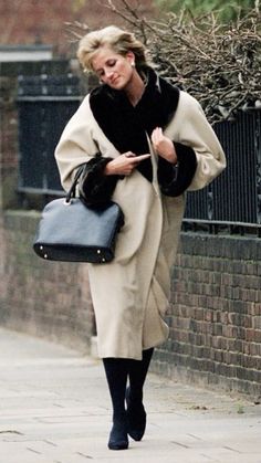 a woman walking down the street carrying a purse