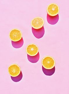 orange slices are arranged on a pink background