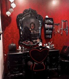 a bedroom with red walls and black furniture in the corner, including a vanity table