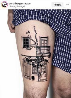 a man with a tattoo on his leg that has a building and flowers in it