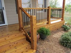 a wooden porch with railing and planters on it