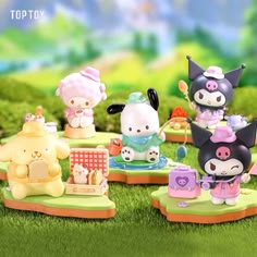 hello kitty figurines are on display in the grass, with other toys around them