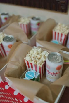 popcorn and sodas are sitting in brown paper bags