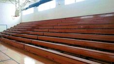 an empty auditorium with wooden seats in the middle and tile flooring on the side