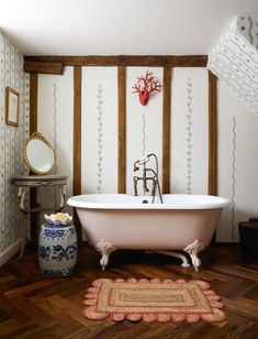 a bathroom with a claw foot tub and wooden floors