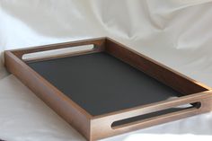 an empty wooden tray with handles on a white sheet