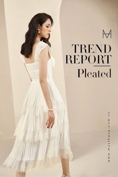 a woman in a white dress standing next to a wall with the words trend report pleated on it