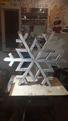 a large snowflake sitting on top of a wooden table