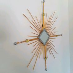 a sunburst made out of wooden sticks and other items on the wall above it