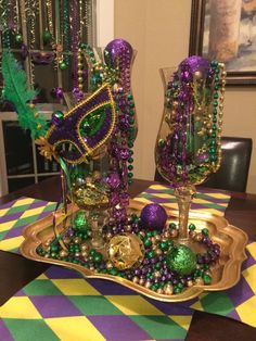 the table is decorated with purple and green beads, glass vases and other decorations