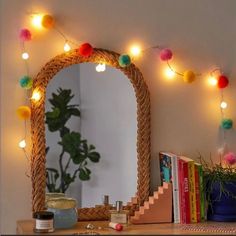 a dresser with a mirror and some books on it