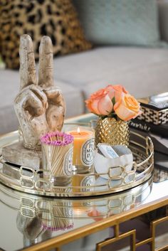 a glass table topped with a peace sign next to a vase filled with flowers and candles