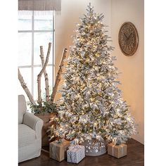 a white christmas tree with lights and presents