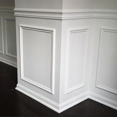 an empty room with white paneling and wood flooring on the walls, along with hard wood floors