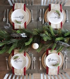 the place setting is decorated with pine cones and evergreen branches