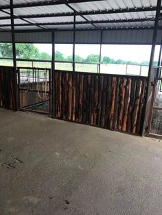 the inside of a building that has been fenced in with wood logs and metal bars