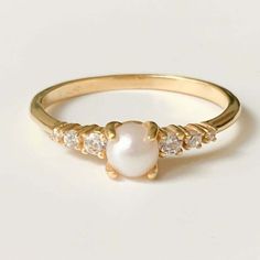 a gold ring with pearls and diamonds on it