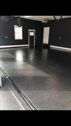 an empty room with black walls and white trim on the floor is seen in this image