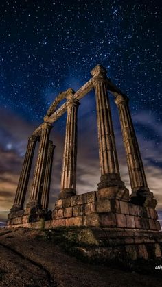 the stars are shining in the night sky above some ancient ruins with columns and pillars