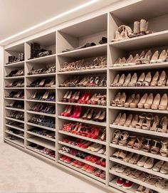 a large white shoe rack filled with lots of pairs of shoes on top of shelves