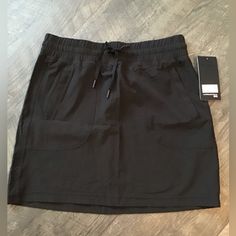 This Skirt Is In New Condition. Side Pockets Have Hidden Zipper .Elastic Waist With Draw String Body Is 88%Polyester And 12% Spandex. Casual Stretch Nylon Skirt, Casual Nylon Stretch Skirt, Casual Nylon Lined Skirt, Casual Nylon Skirt With Relaxed Fit, Casual Relaxed Nylon Skirt, Sporty Black Lined Skirt, Loose Fit Nylon Casual Skirt, Casual Solid Nylon Skirt, Casual Black Nylon Skort