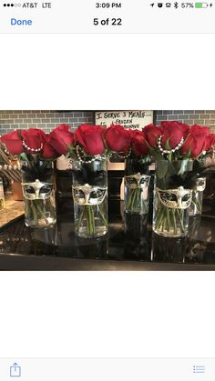 several vases with roses in them sitting on a table