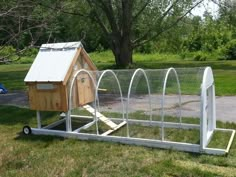 a chicken coop on wheels in the grass