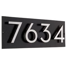 a black and white house number sign with the numbers 765 - 744 on it