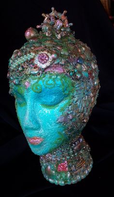 a blue and green head with lots of beads on it