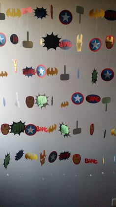 the wall is decorated with many different types of stickers on it, including batman and superman logos