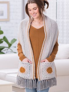 a woman wearing a crocheted cardigan with fringe