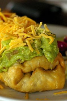 an enchilada with cheese and guacamole on it