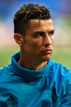 the head and shoulders of a soccer player in blue jersey looking off into the distance