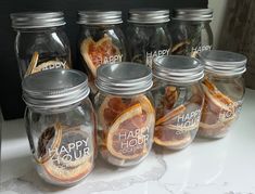 several jars filled with orange slices and happy hour on top of a white countertop