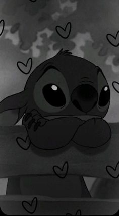 a black and white photo of a cartoon character sitting on a bench surrounded by hearts