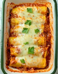 an enchilada casserole with cheese and parsley in a green dish