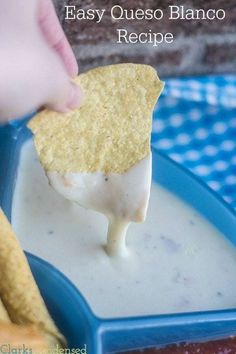 a person dipping cheese into a bowl of quesadilla sauce with tortilla chips