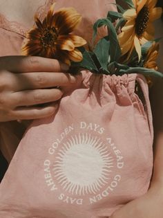 a person holding a bag with sunflowers in it