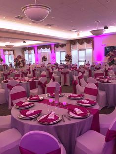 a banquet room set up with purple and white linens