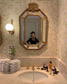 a woman is taking a selfie in the bathroom mirror while stacked with toilet paper