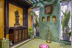 a living room with green walls and gold accents on the floor, along with an ornately decorated sideboard