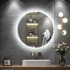 a bathroom with a sink, mirror and lights on the wall above it's counter