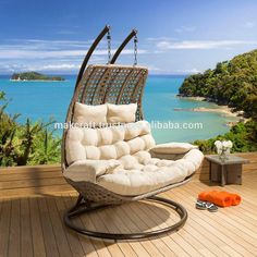 a swing chair sitting on top of a wooden deck