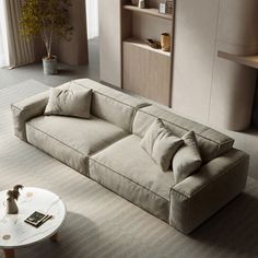 a living room filled with furniture and a white coffee table in front of a window