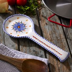 a spoon sitting on top of a wooden table next to tomatoes and other food items