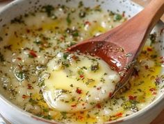 a wooden spoon in a white bowl filled with soup