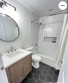 a bathroom with black and white flooring and hexagonal tiles on the walls