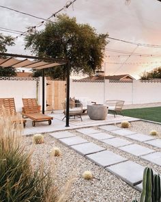 an outdoor patio with seating and plants in the foreground, surrounded by graveled walkways