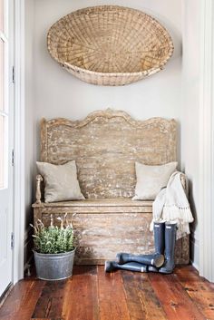 a wooden bench sitting on top of a hard wood floor next to a potted plant